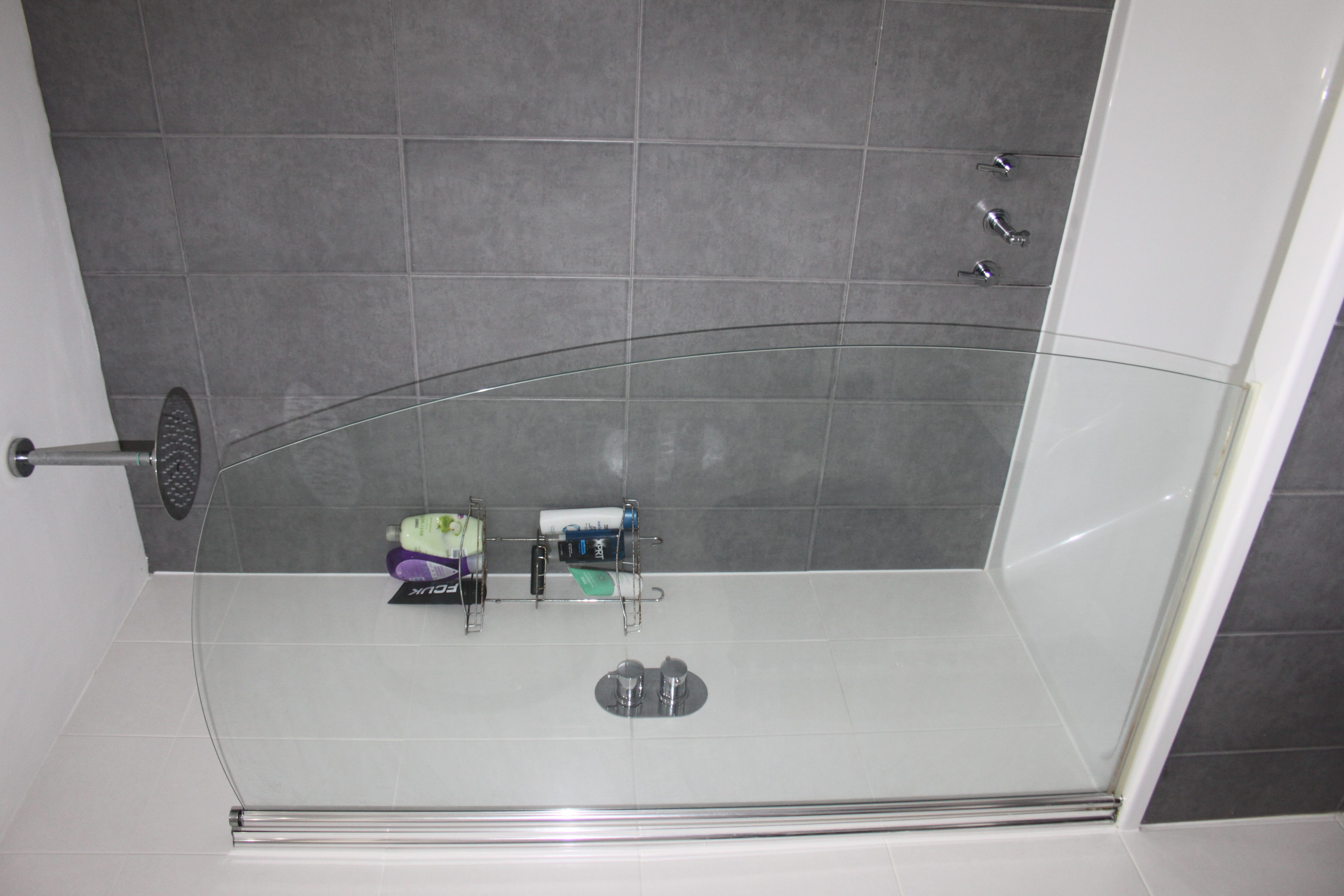 small bathroom with modern shower, grey tiling, fitted bath