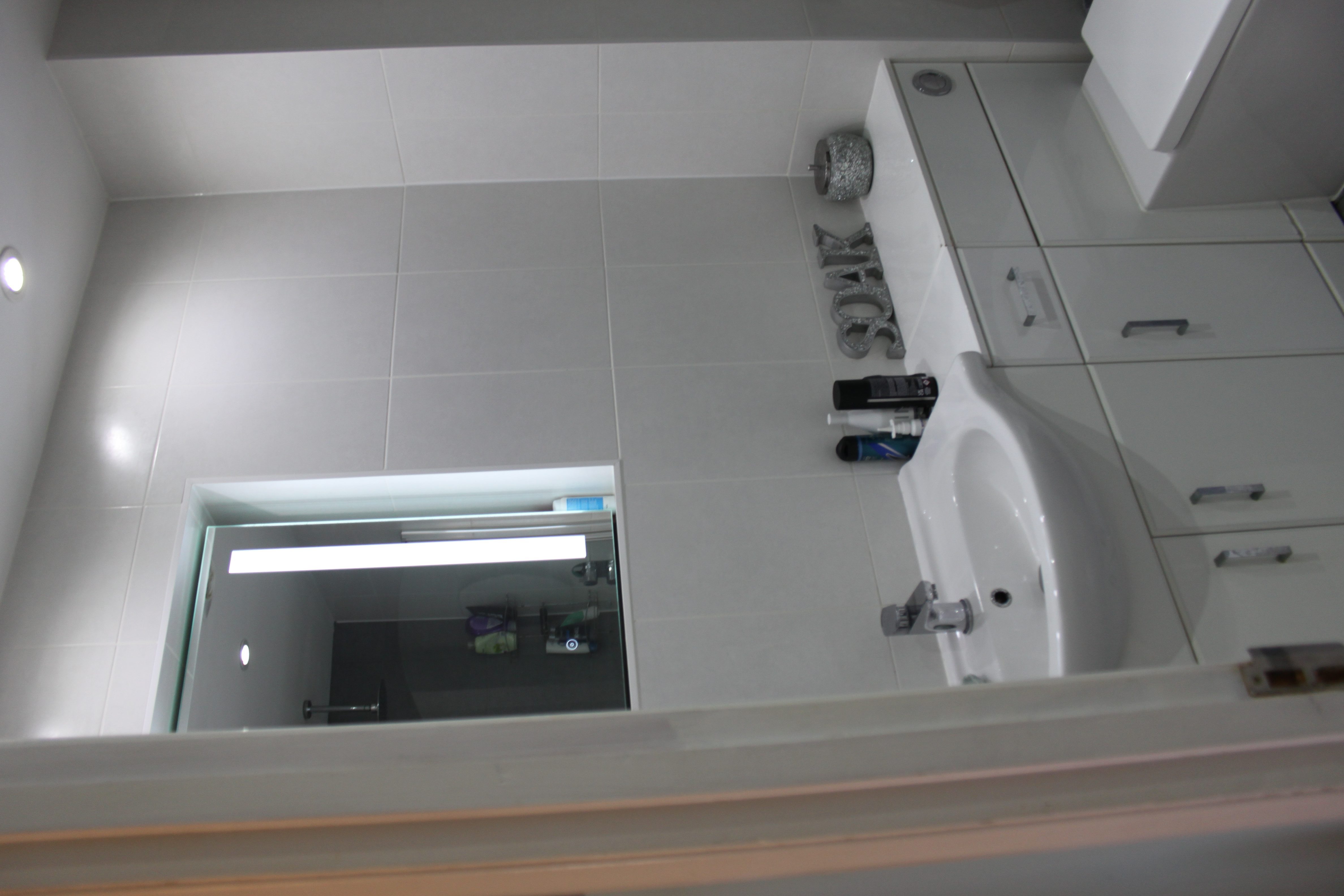 small bathroom with modern shower, grey tiling, fitted bath