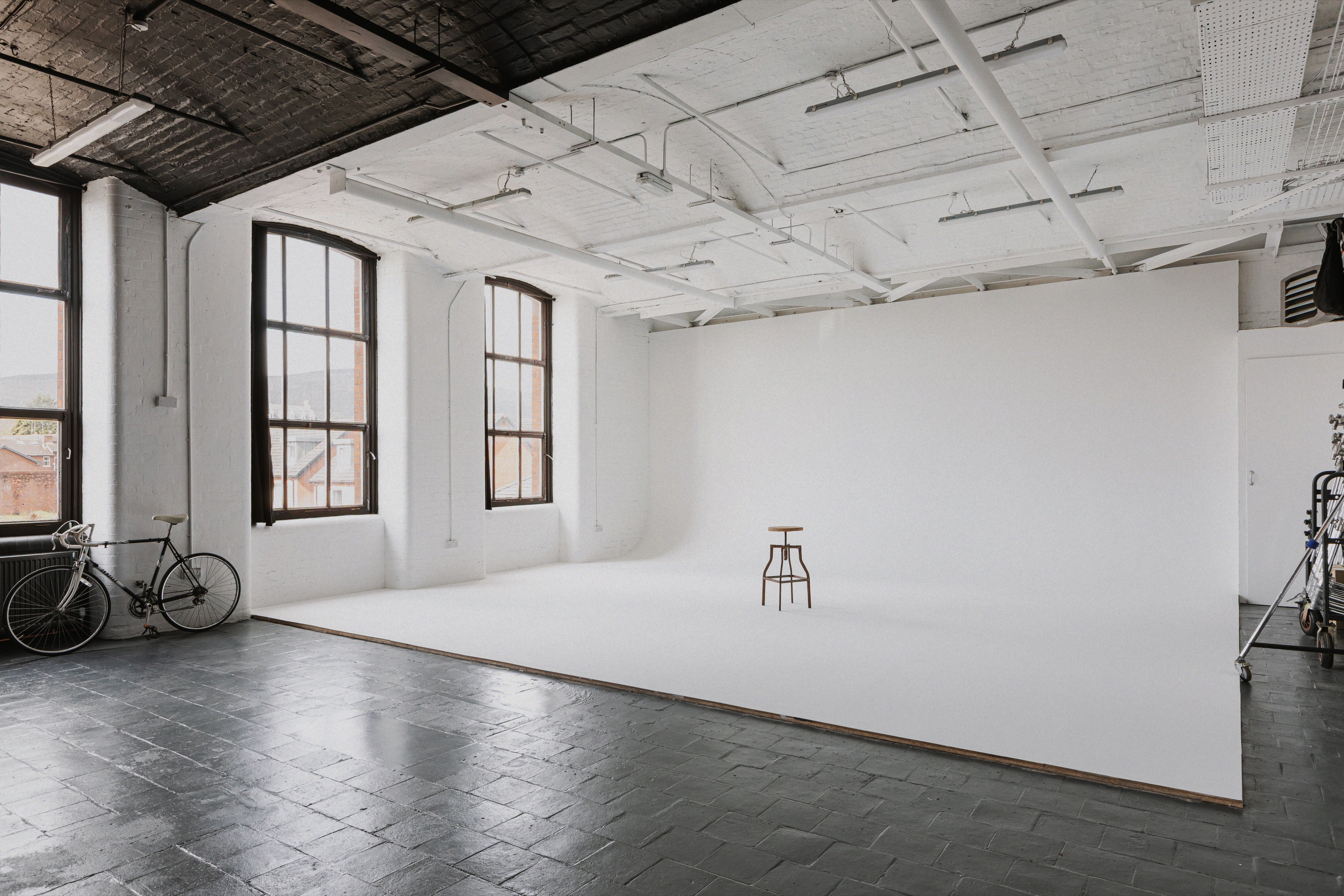 Large white infinity cove with tall windows in an industrial Belfast studio.